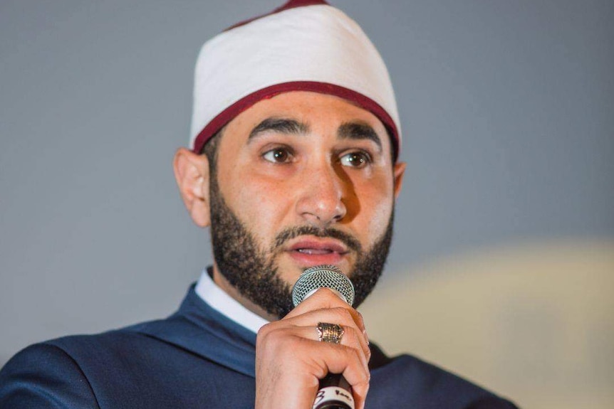 A close up of Sheikh Alaa speaking into a microphone. 