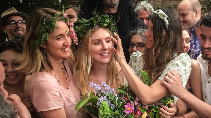 Bride surrounded by friends at wedding in a story about women marrying without partners.