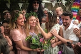 Bride surrounded by friends at wedding in a story about women marrying without partners.