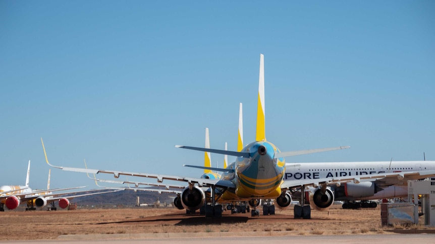 Large planes with different logos sit at Alice Springs airport facility.