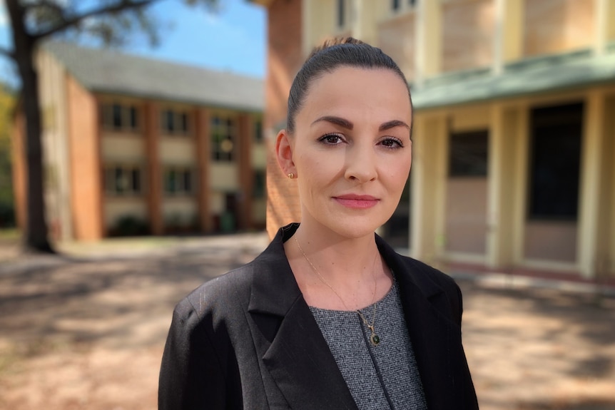 A woman standing in front of university buildings