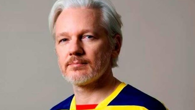 Julian Assange wears an Ecuador football jersey.
