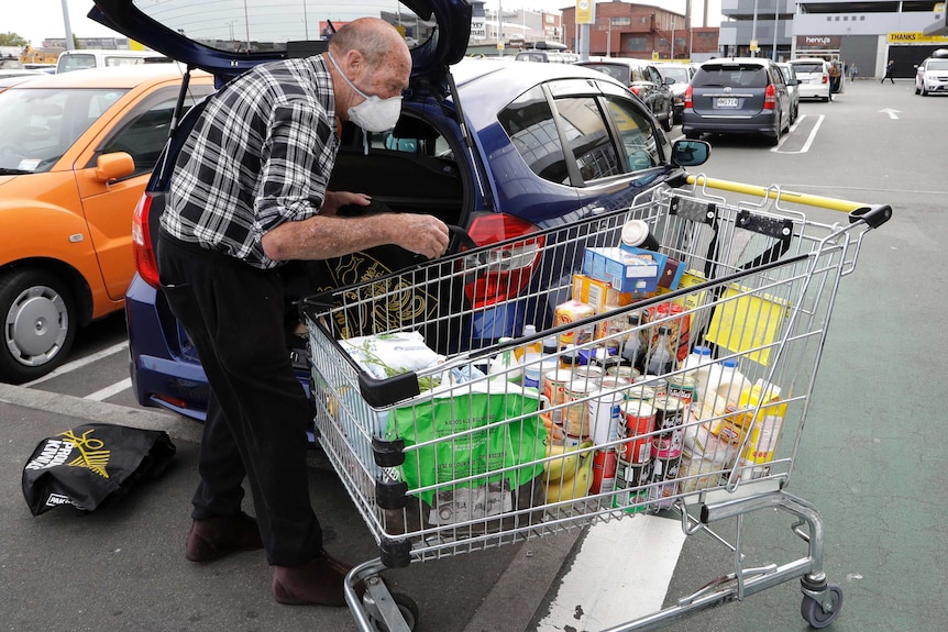 A man unpacks his shopping trolley in the carpark at a supermarket in central Christchurch, New Zealand.