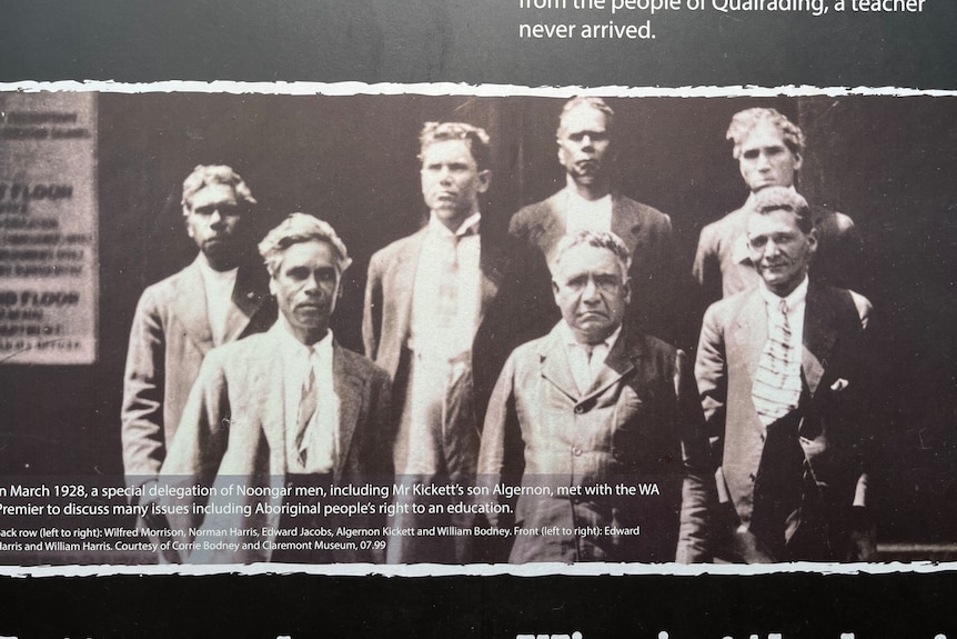 A black and white photos of seven Aboriginal men in suits posing for the camera.