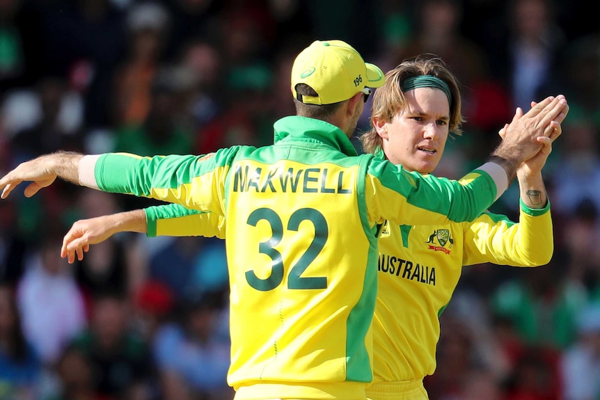 Glenn Maxwell, with his back to camera, gives a high 10 to Adam Zampa.