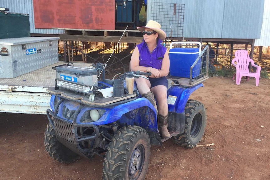 A lady sits on a quad bike.