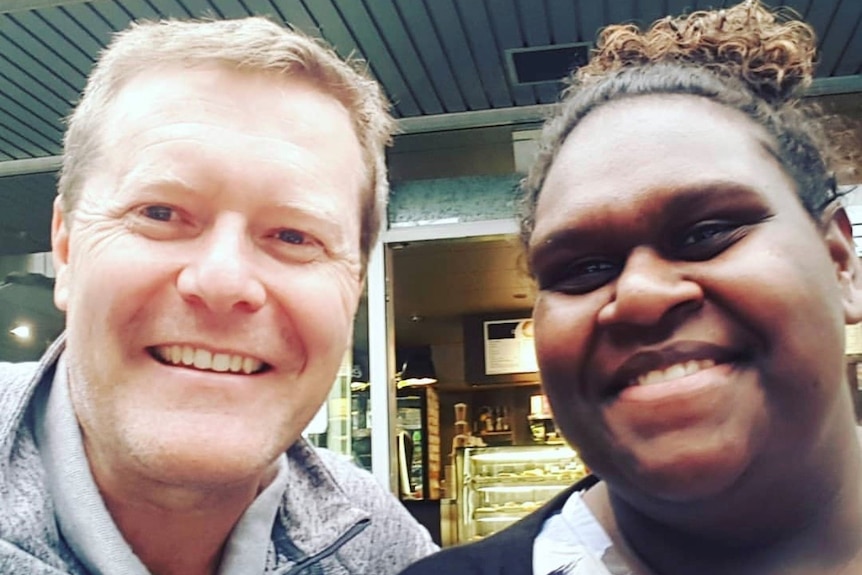 James Christie and Naz Wapau smiling outside a coffee shop.