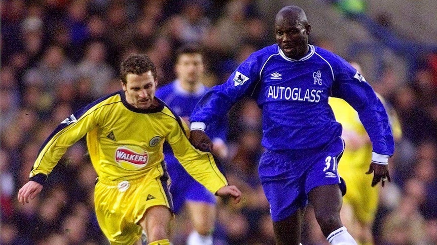 George Weah about to kick a ball on the football field.