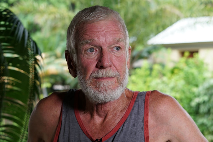 Head-and-shoulders shot of grey-haired, bearded man wearing a singlet.