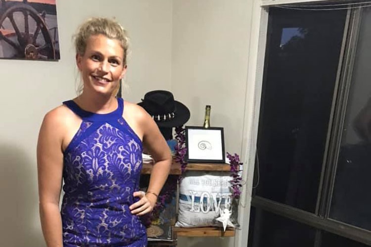 Rychelle Vines poses in a formal blue dress in her loungeroom with her dog as part of the Friday Formal Frock-Up.