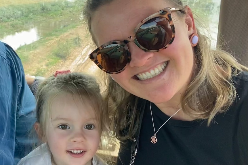 A young girl and her mother smiling