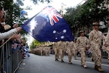 A member of the crowd waves an Australian flag