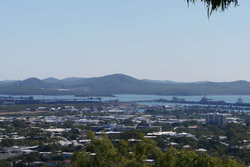 Blue sky over a city skyline that reaches a deep water port.