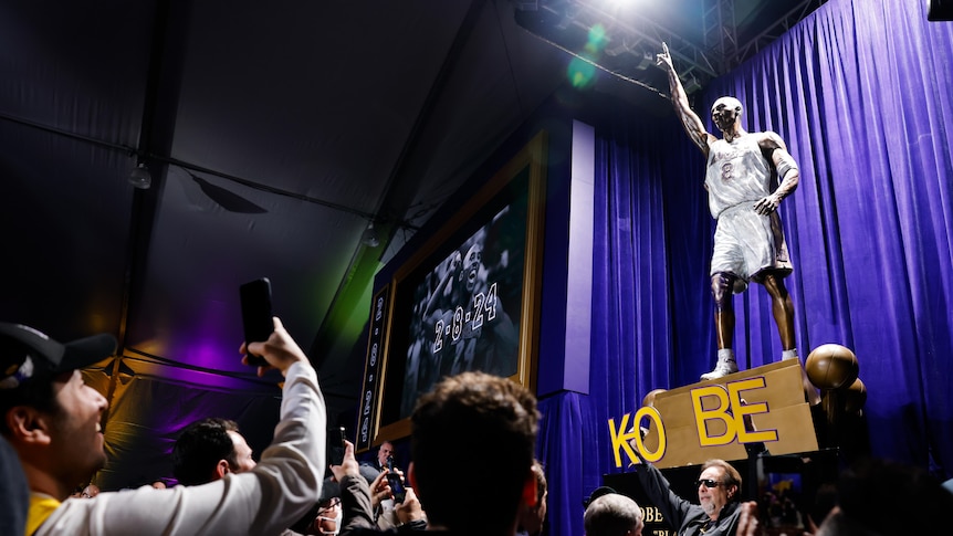 Fans look at a Kobe Bryant statue