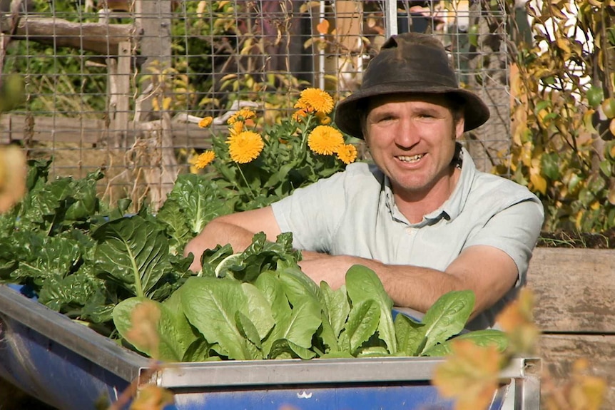 A man in a garden wearing a hat