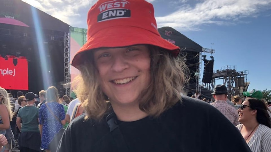 A teenager at a music concert smiling at the camera.