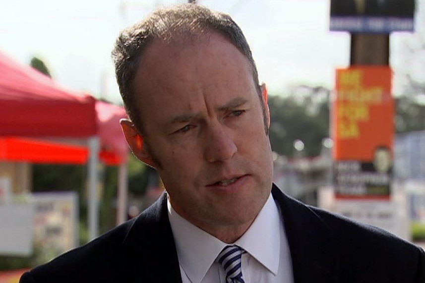 Matthew Wright speaks in front of election signs.