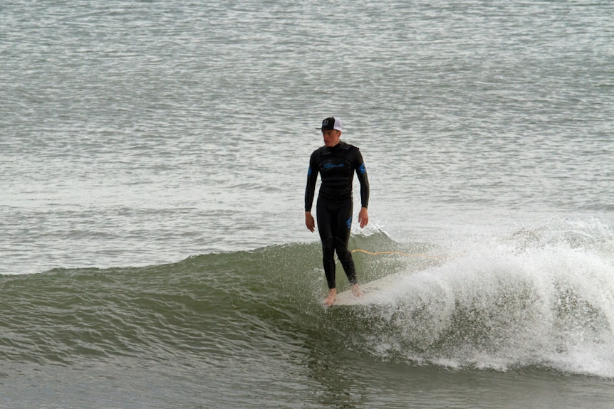 Tom Kelly surfs a wave