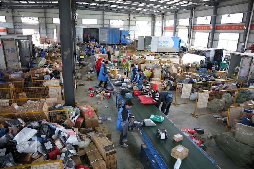 Workers pack boxes in a warehouse.