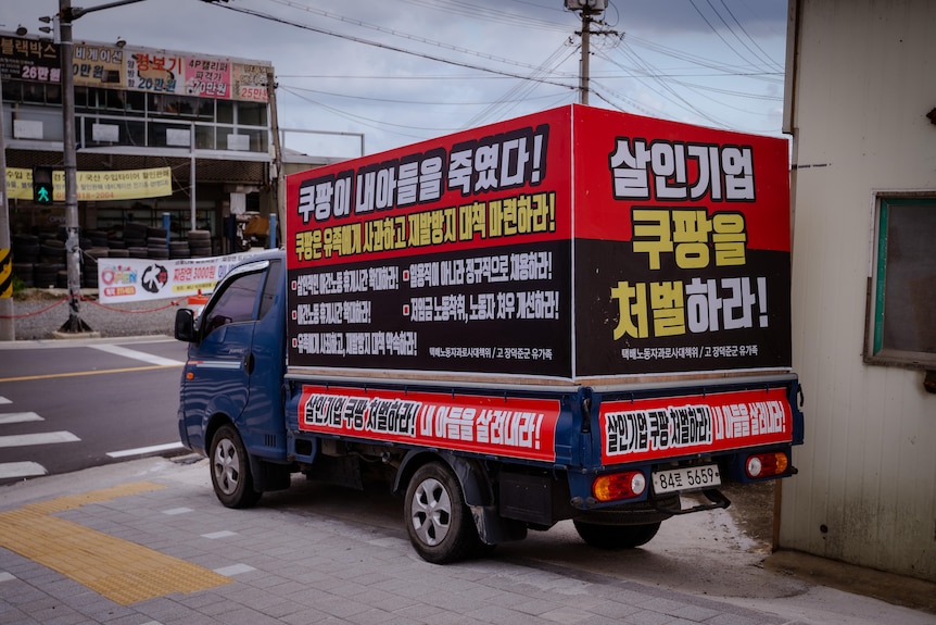 A van with the words "Coupang killed my son" on it.