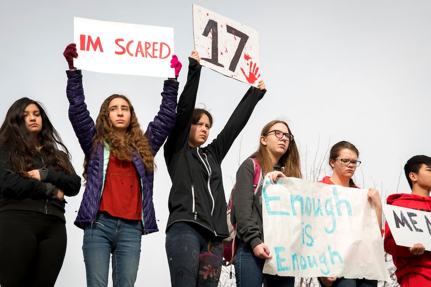 Students recognise the 17 victims, holding the number 17 and posters reading "i'm scared" and "enough is enough"