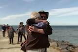 Derek Robinson hugging a friend on land at Encounter Bay