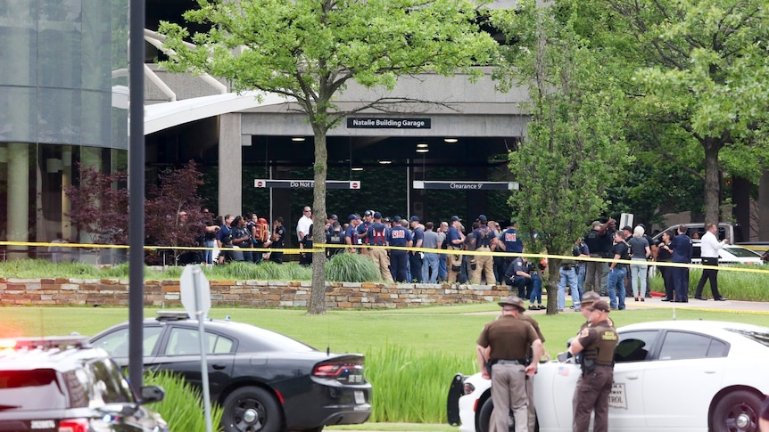 An exterior shot of the Natalie Medical Building with a crowd of first responders outside. 