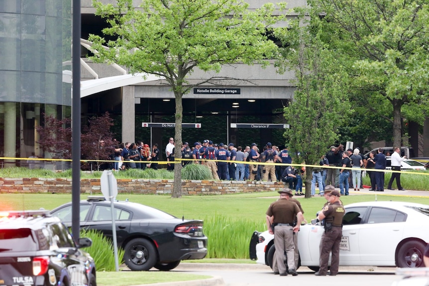 An exterior shot of the Natalie Medical Building with a crowd of first responders outside. 