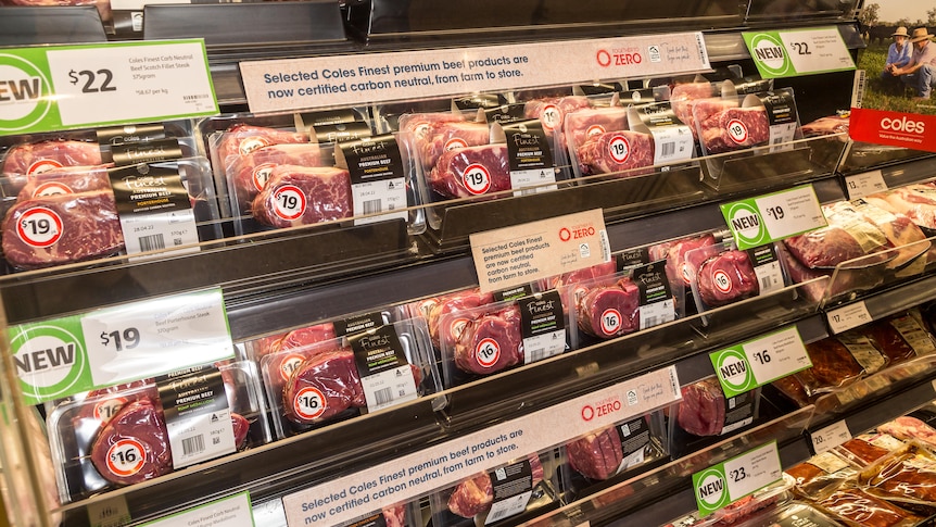 a supermarket fridge section full of steak