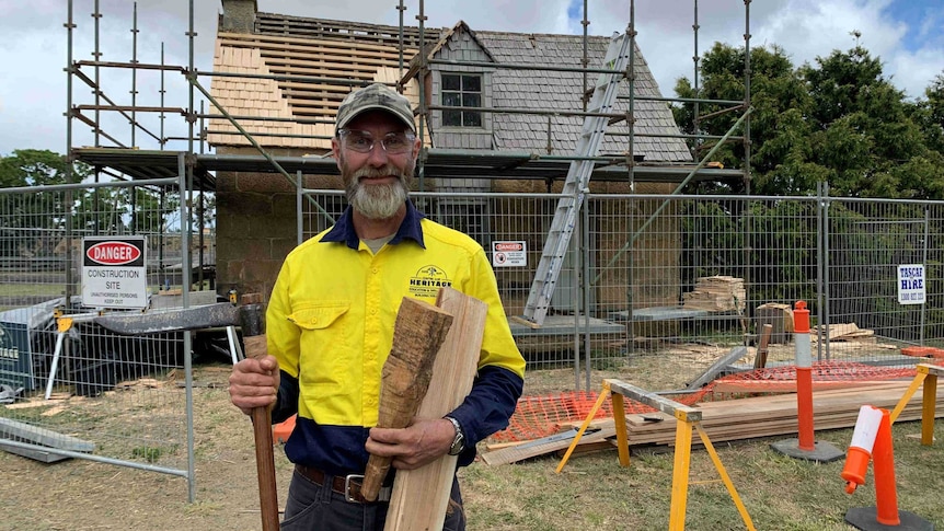 Builder Graham Green standing in front of a heritage cottage under renovation