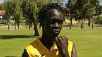 Teenager Kuol Atuk, standing in a park with his sporting jersey, died after falling into a coma at a party in Girrawheen.