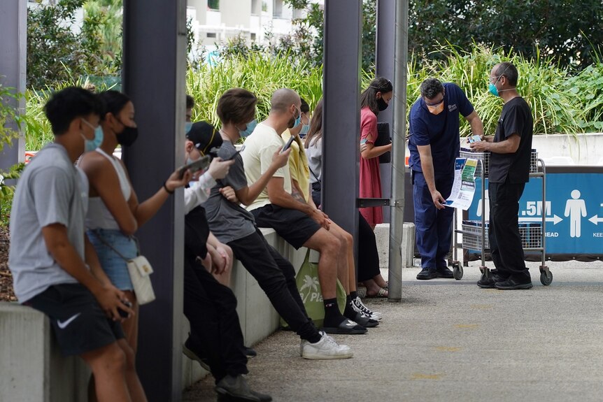 Queue of eligible people to get free RAT packs from health staff outside the Royal Brisbane and Women's Hospital in Brisbane.