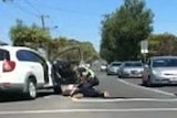 Mobile phone footage of an alleged assault on a boy outside a car by a police officer.