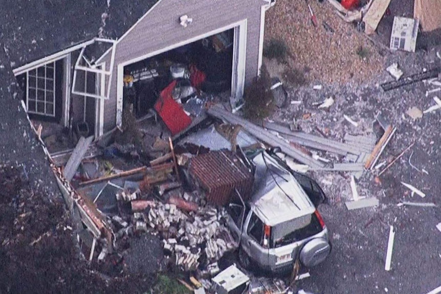 Debris and the upper portion of a brick chimney crushed an SUV parked in the driveway of a home at North Andover, Massachusetts.