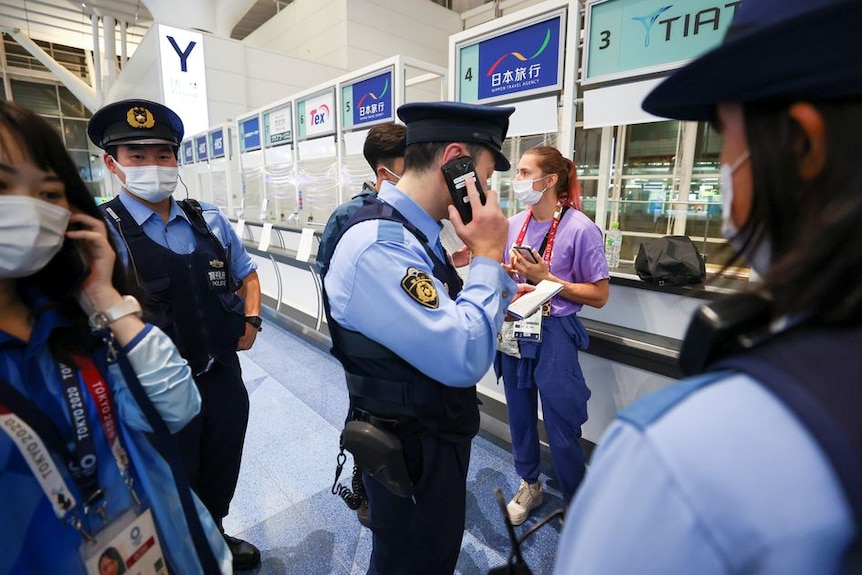 A women on the phone surrounded by police.