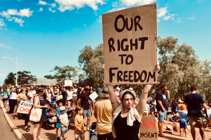 Woman standing with a sign at a protest.