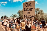 Woman standing with a sign at a protest.