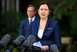 Queensland Premier Annastacia Palaszczuk speaking to reporters, with Health Minister Steven Miles in the background