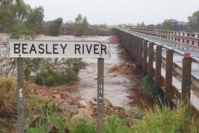 Water rises just beneath a bridge as a river breaks its banks.