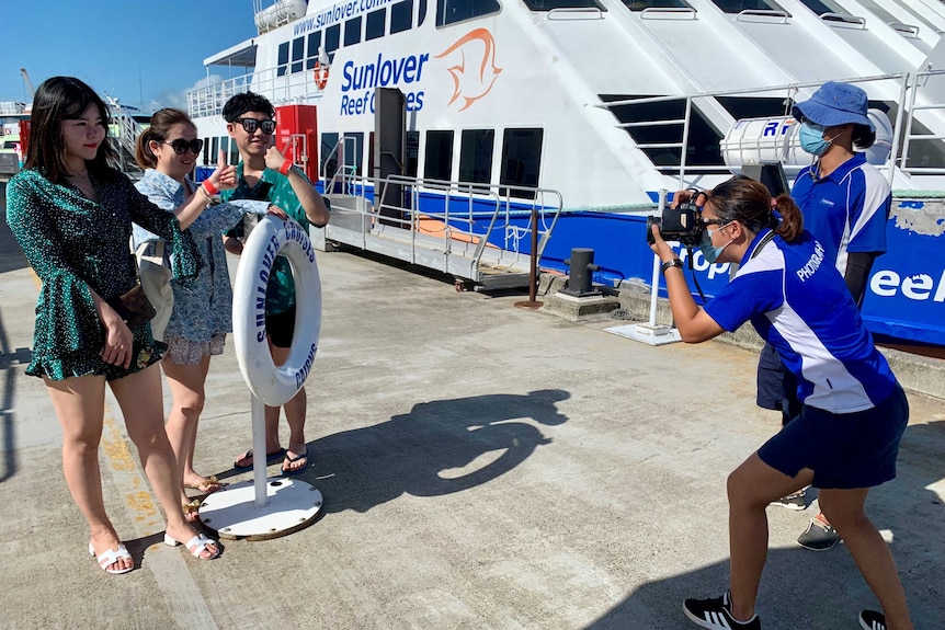 Chinese tourists being photographed alongside a reef tour boat