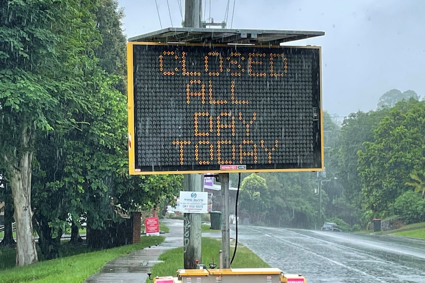 An electronic sign reads "closed all day today" in the rain