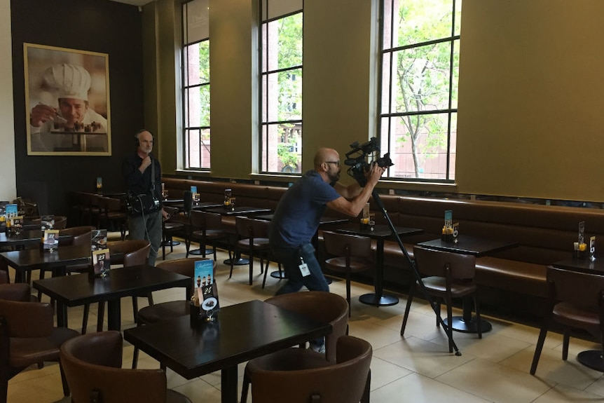 Cameraman Louie Eroglu filming inside the Lindt Cafe for Four Corners.