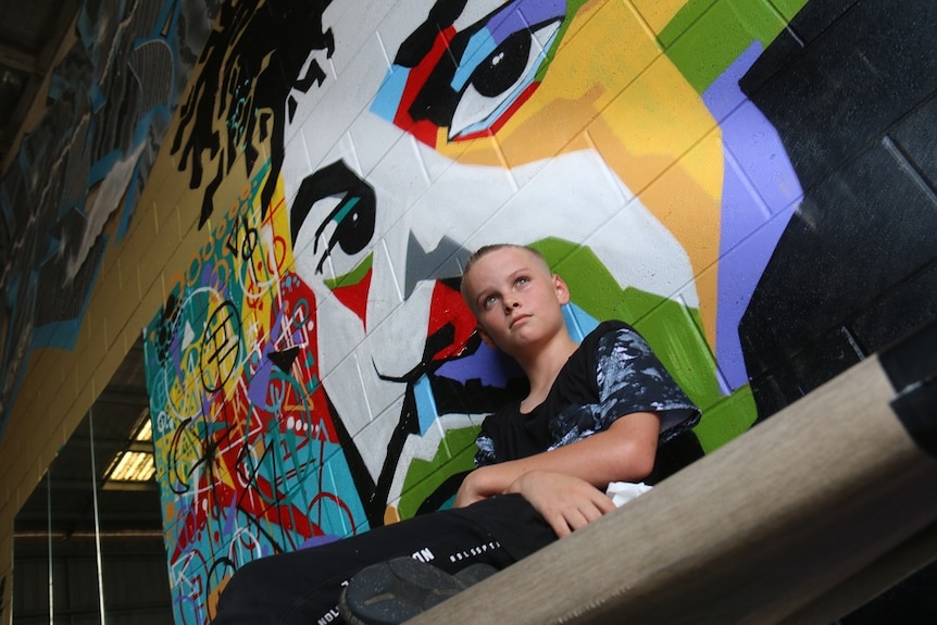 David james sitting in dance studio in front of graffitied wall