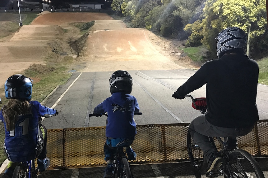 Young and old BMX riders lined up at a track in Launceston.