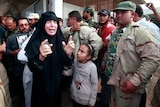 A woman reacts after seeing the corpse of toppled Libyan dictator Moamar Gaddafi