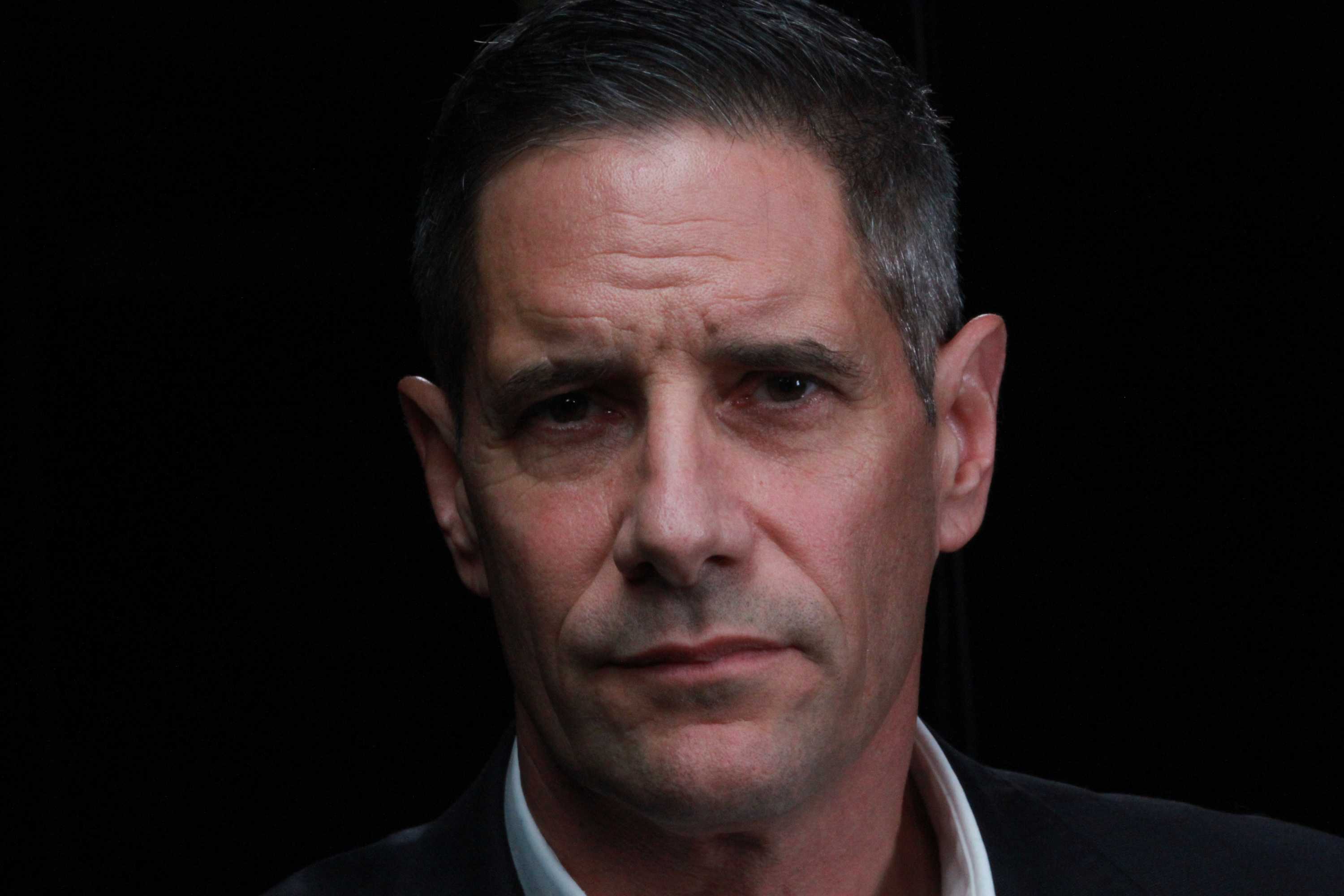 Roman Quaedvlieg wears a white collared shirt and dark suit jacket.