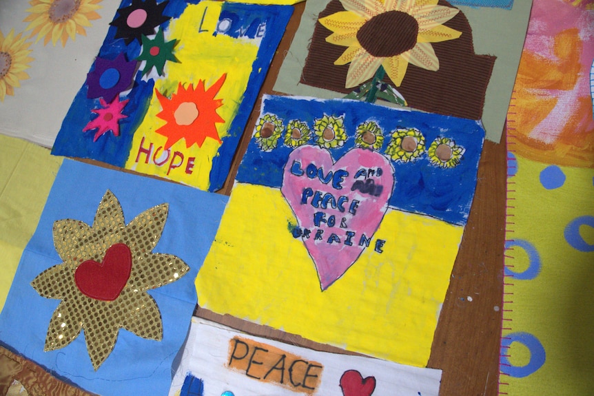 Handmade quilt patches, one reads 'love and peace for Ukraine'.