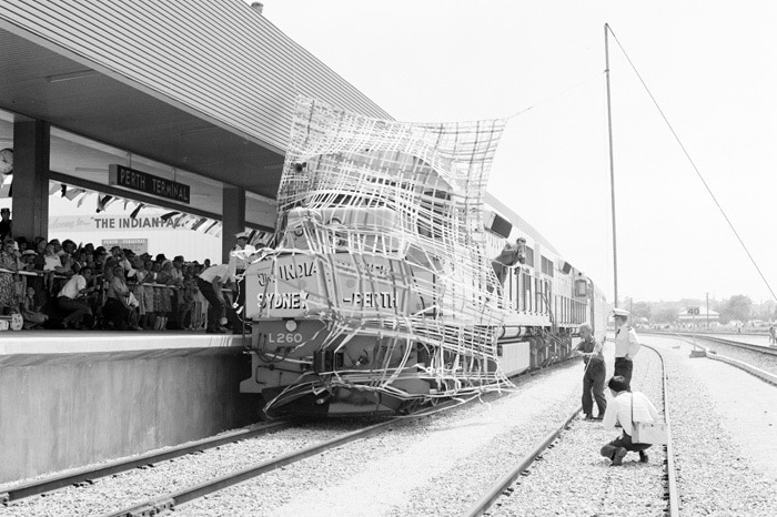 People waiting on a railway platform as a train pulls in.