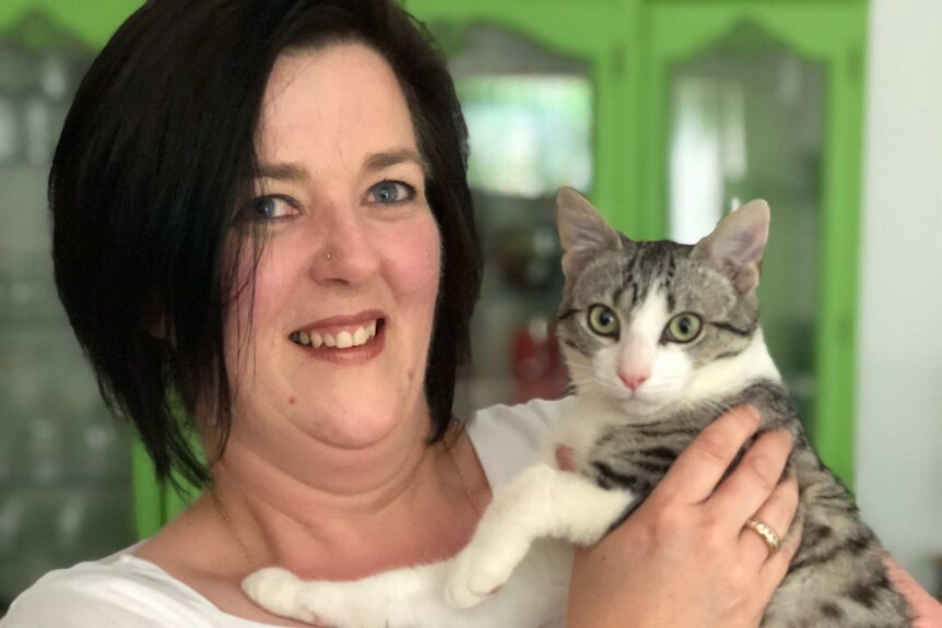 Volunteer animal carer Vanessa Parton with a grey and white cat named Patrick.