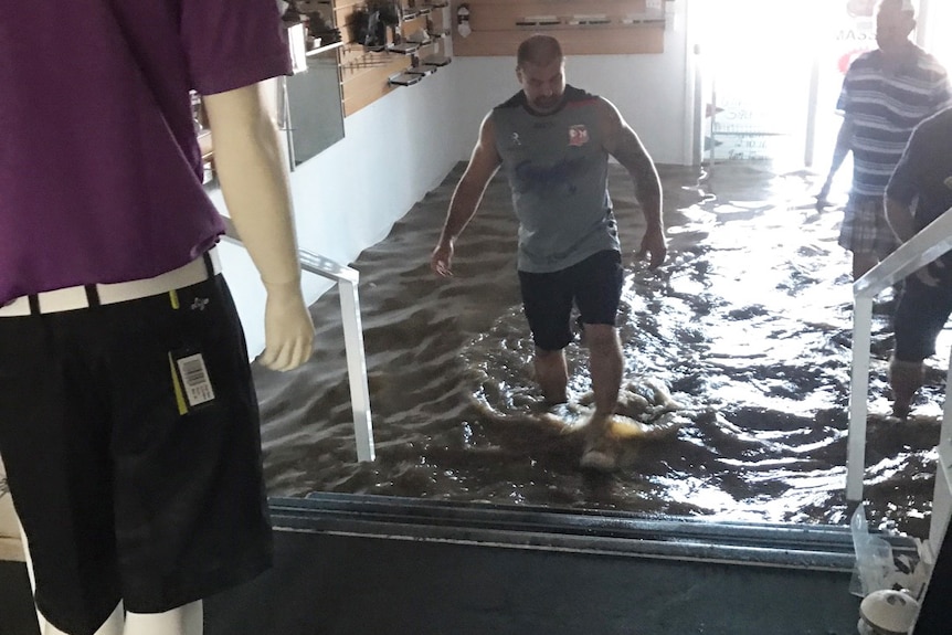 People from the community help clear out the flooded Mount Warren Golf Club